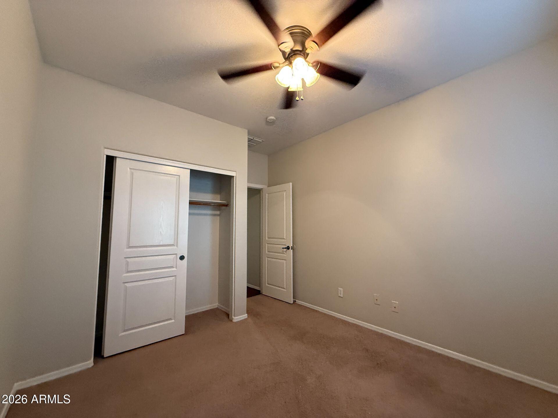 14641 West Hearn Road Surprise, AZ 85379 - Photo 22 of 42 an empty room with closet and a ceiling fan