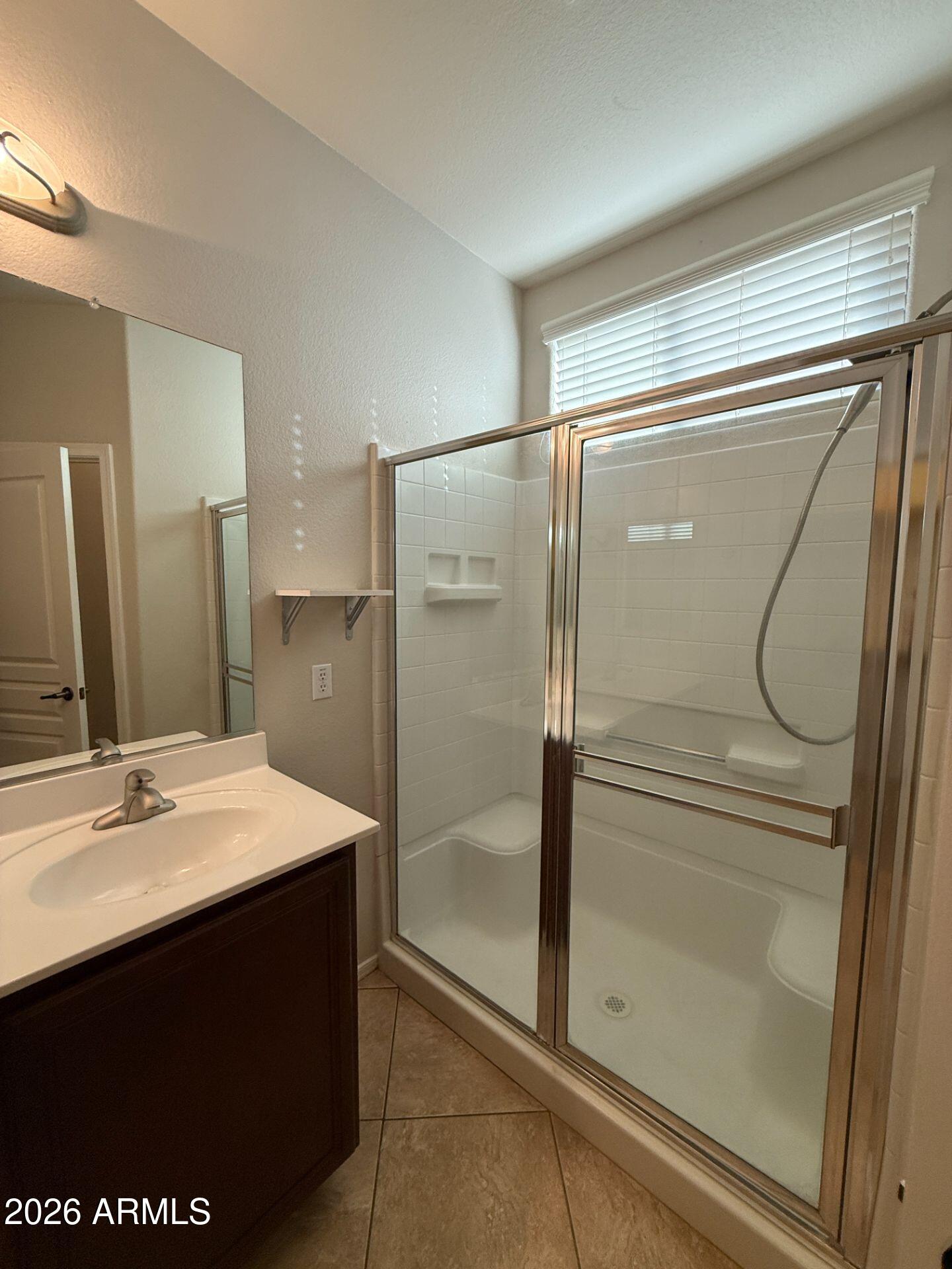 14641 West Hearn Road Surprise, AZ 85379 - Photo 25 of 42 a bathroom with a shower sink vanity and mirror