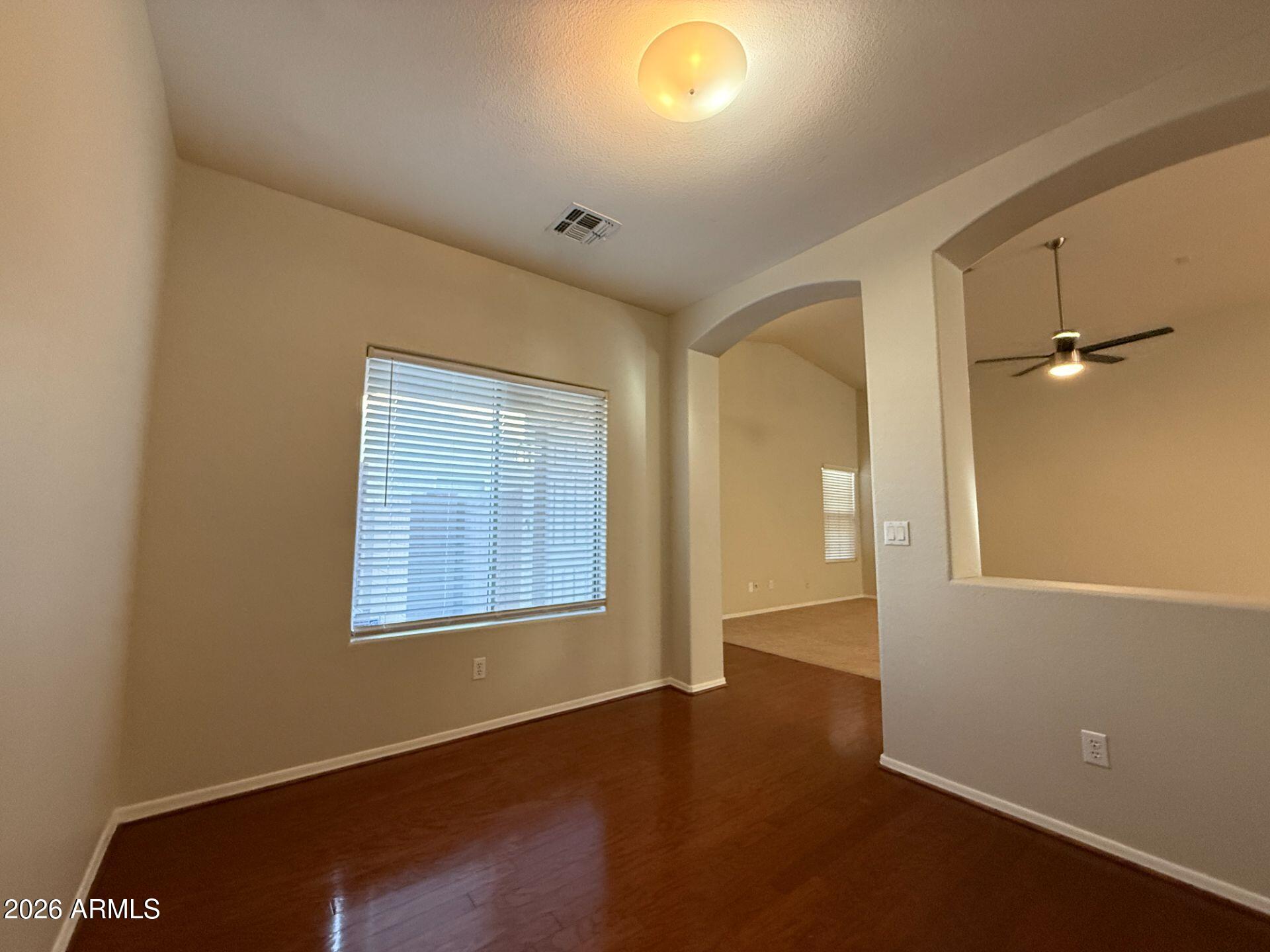 14641 West Hearn Road Surprise, AZ 85379 - Photo 4 of 42 an empty room with wooden floor and windows