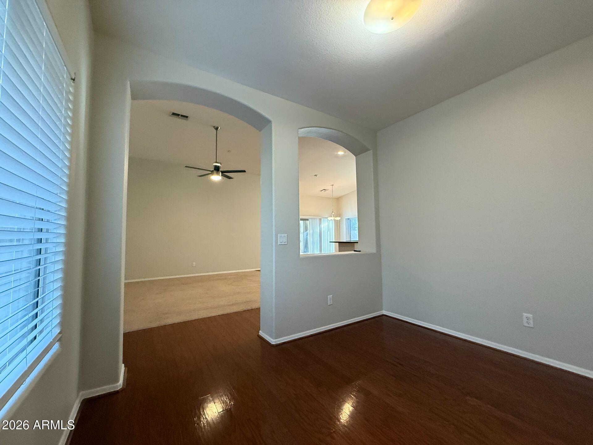 14641 West Hearn Road Surprise, AZ 85379 - Photo 5 of 42 an empty room with wooden floor and windows