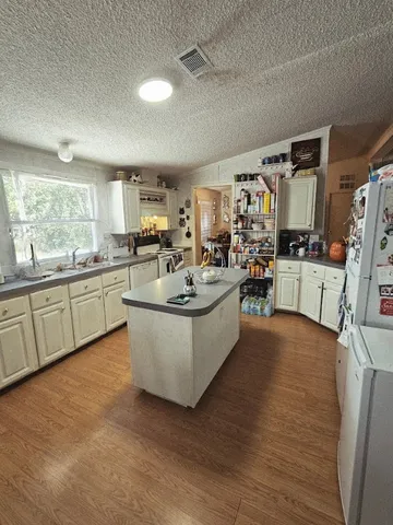 a living room with stainless steel appliances granite countertop furniture wooden floor and a view of kitchen