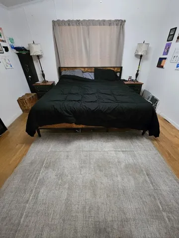 a bedroom with a bed a window and dresser