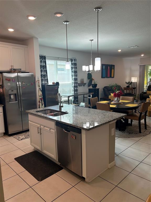 377 Vestrella Drive Kissimmee, FL 34759 - Photo 3 of 12 a kitchen with stainless steel appliances granite countertop a sink a stove and a refrigerator