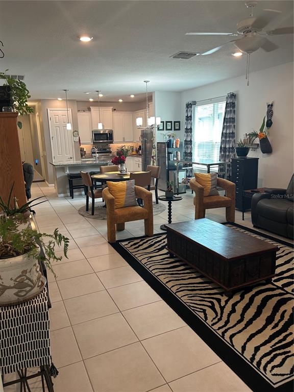 377 Vestrella Drive Kissimmee, FL 34759 - Photo 4 of 12 a living room with furniture a rug and a flat screen tv