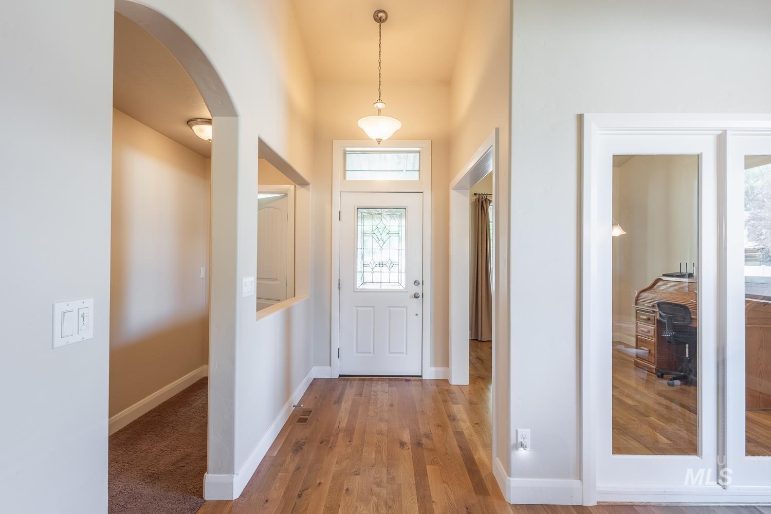 1186 East Observation Street Meridian, ID 83642 - Photo 7 of 33 Entryway featuring wood-finish flooring, a decorative pendant light, and a white front door with leaded glass