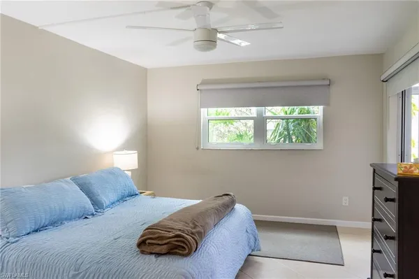 a bedroom with a bed and a large mirror on dresser