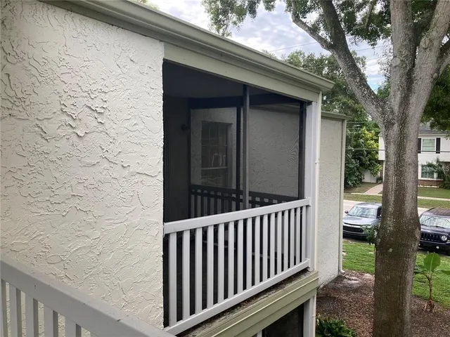a view of a porch with a floor to ceiling window and wooden fence