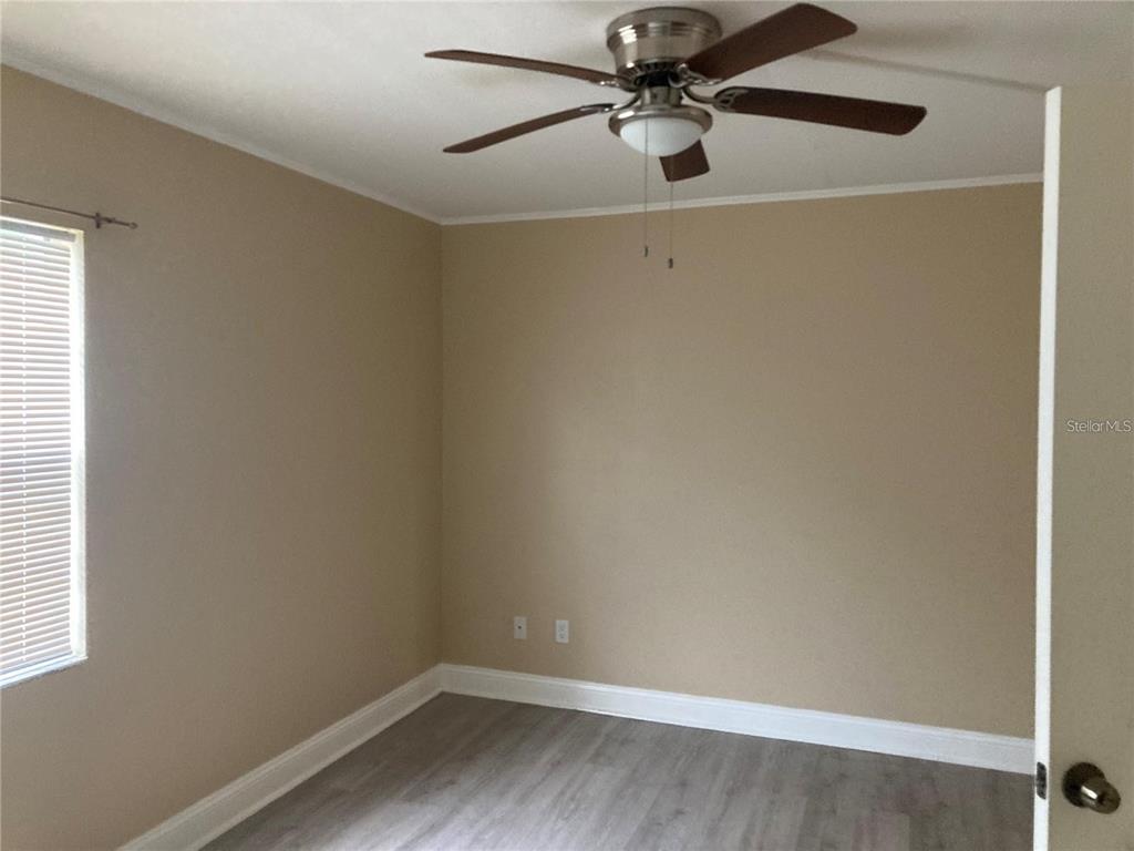 4611 West North B Street, Unit 220 Tampa, FL 33609 - Photo 9 of 11 a view of a small space with wooden floor and fan