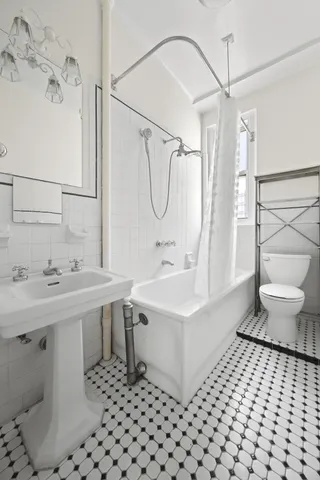 a bathroom with a sink a toilet a mirror and shower