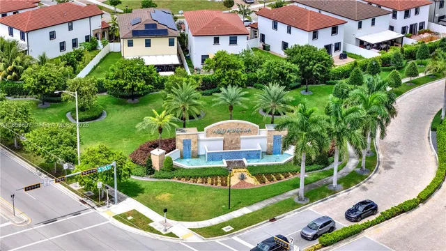a view of a multi story residential apartment building with a yard and plants
