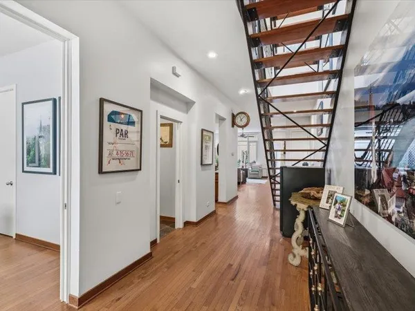 a view of a hallway with wooden floor and staircase