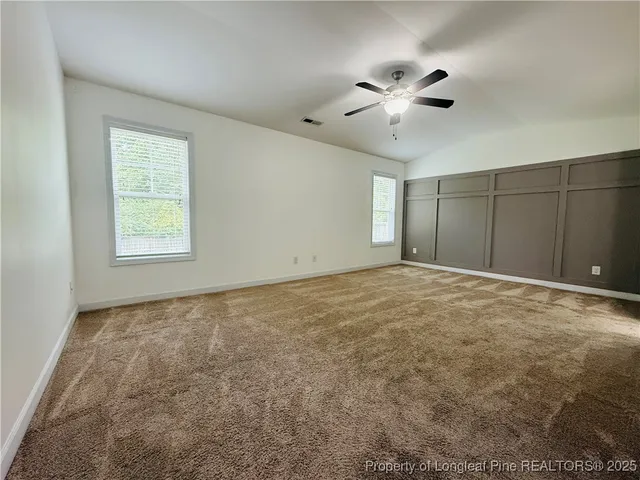 an empty room with closet and a ceiling fan