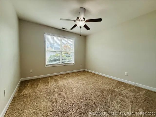 an empty room with fan and a ceiling fan