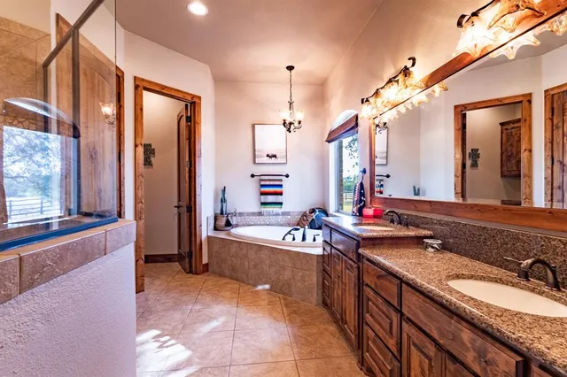 a spacious bathroom with a bathtub sink and mirror