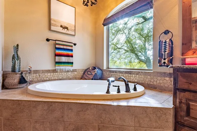 a bathroom with a granite countertop sink and a large mirror