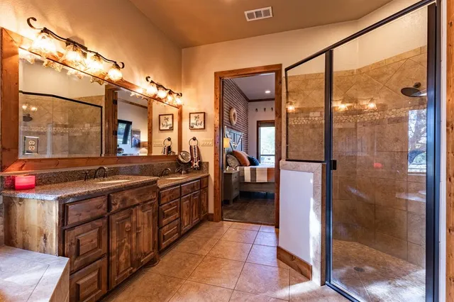 a spacious bathroom with a granite countertop shower a sink and a mirror