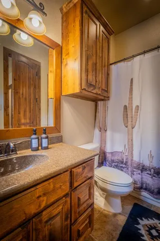 a bathroom with a granite countertop sink toilet and a mirror