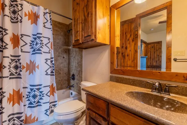 a bathroom with a granite countertop sink a toilet and a mirror
