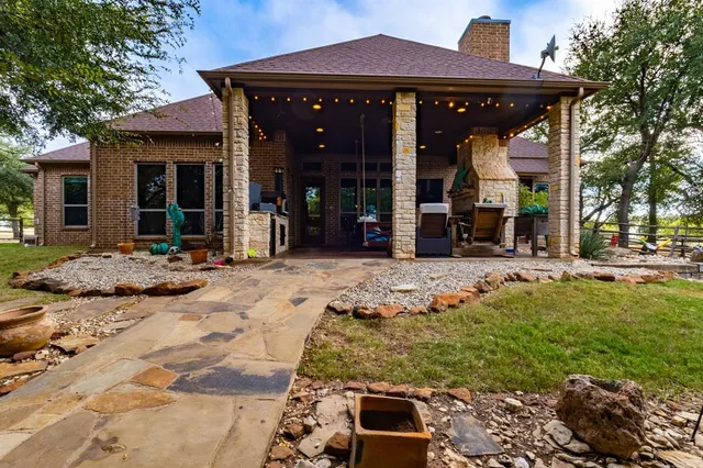 a view of a house with floor to ceiling windows and a yard