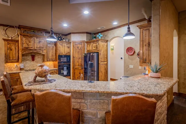 a kitchen with stainless steel appliances granite countertop sink stove top oven and cabinets