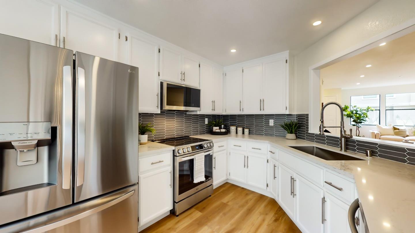 994 La Mesa Terrace, Unit E Sunnyvale, CA 94086 - Photo 8 of 28 a kitchen with white cabinets and stainless steel appliances