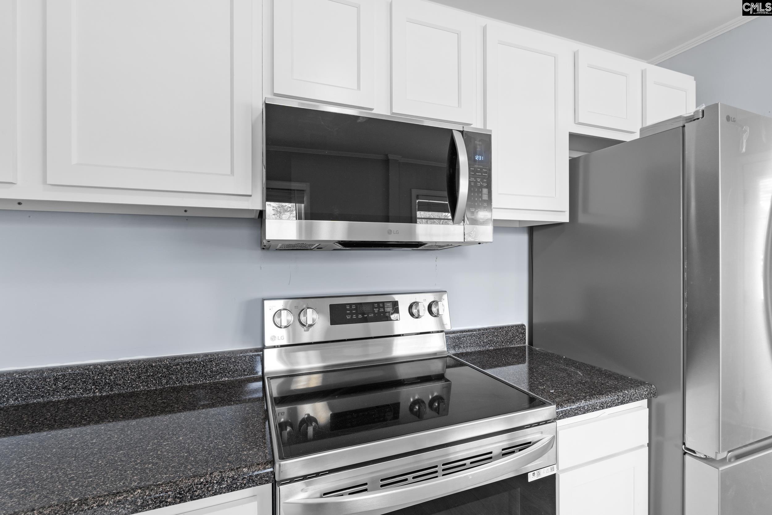 409 Wilkes Road Columbia, SC 29203 - Photo 11 of 34 a kitchen with stainless steel appliances granite countertop white cabinets and a stove a oven with white countertops