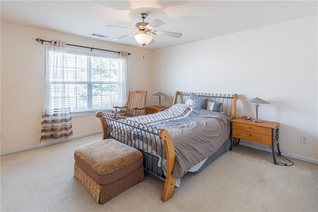 2182 Hyssop Way Buford, GA 30519 - Photo 12 of 16 a bedroom with a bed a chair and a large window