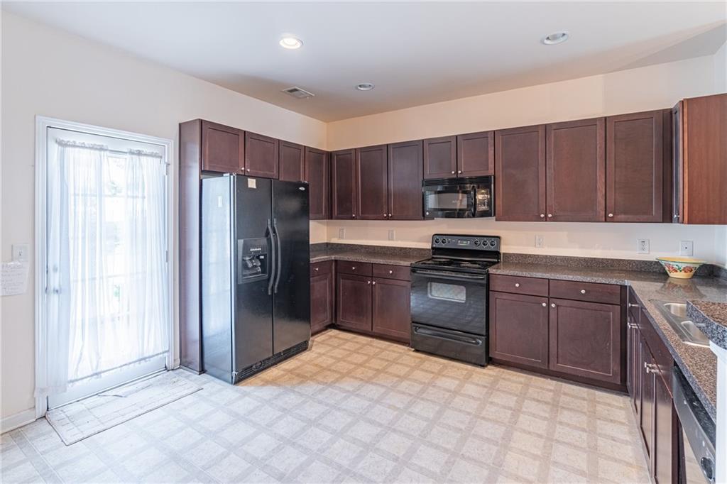 2182 Hyssop Way Buford, GA 30519 - Photo 6 of 16 a kitchen with granite countertop a refrigerator and a stove top oven