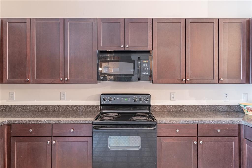 2182 Hyssop Way Buford, GA 30519 - Photo 8 of 16 a kitchen with granite countertop wood cabinets and stainless steel appliances
