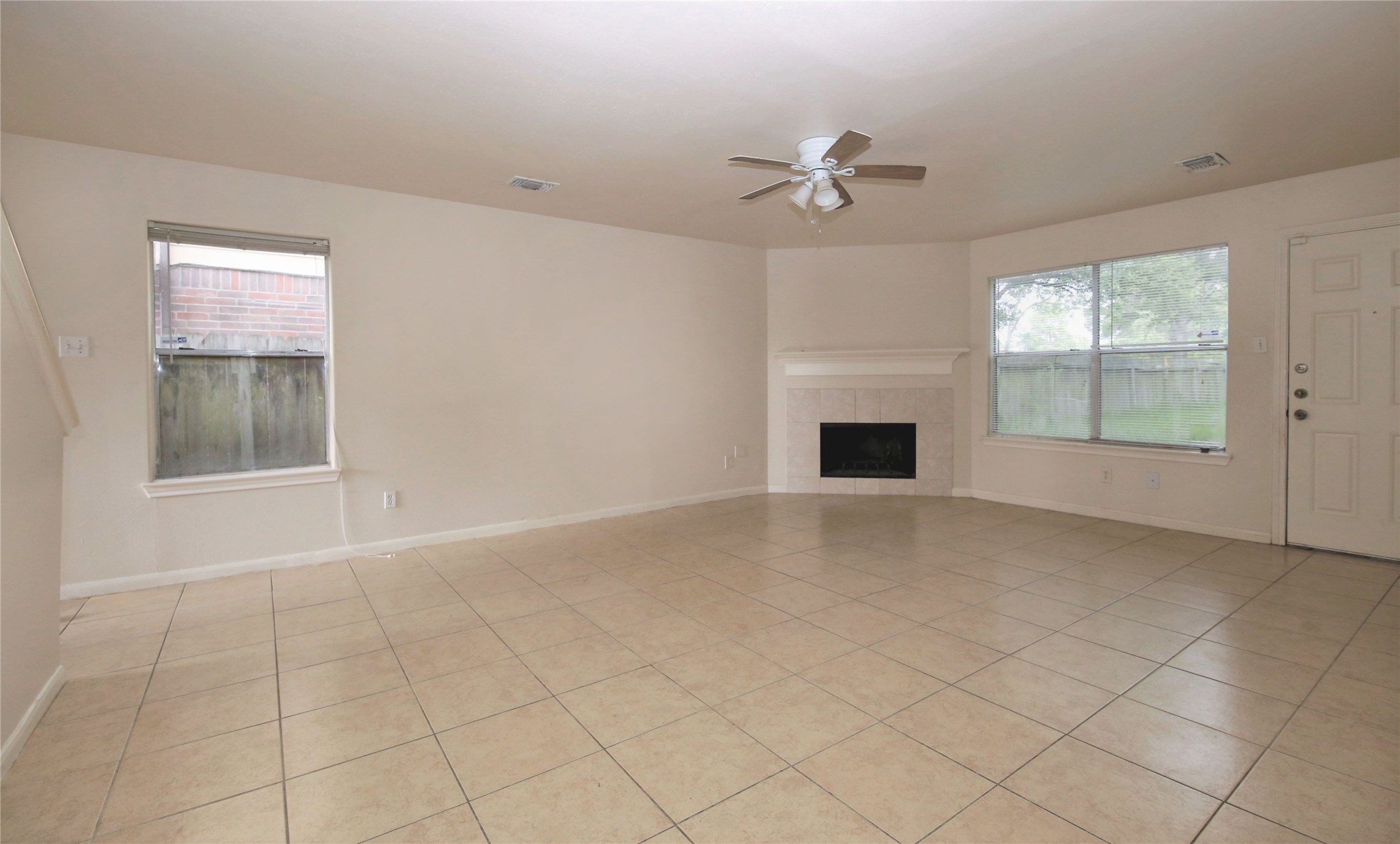 6923 Cheshire Park Road Houston, TX 77088 - Photo 3 of 9 an empty room with windows and fireplace