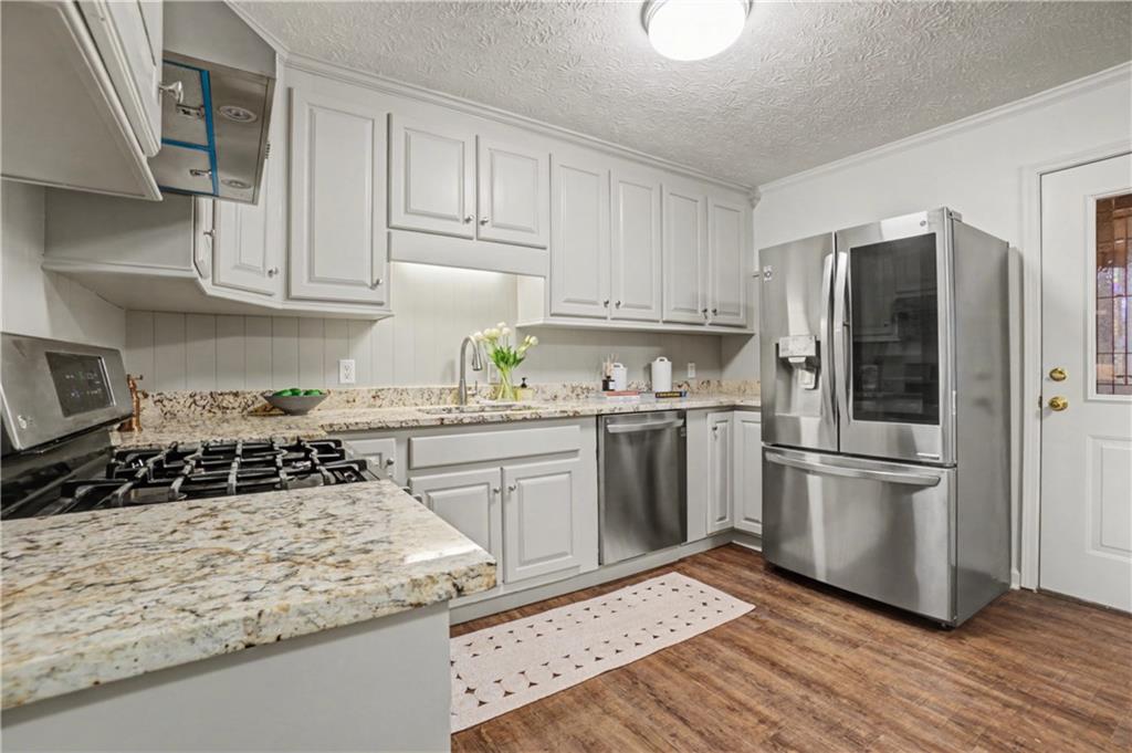 520 Victoria Road Woodstock, GA 30189 - Photo 11 of 42 a kitchen with a refrigerator stove and wooden cabinets