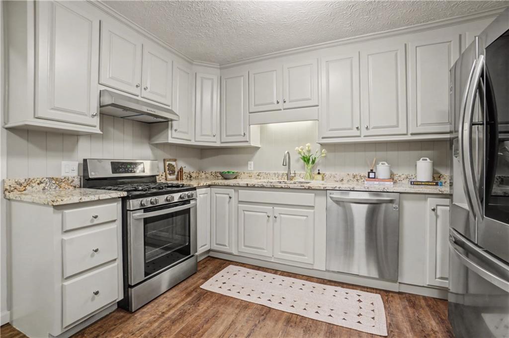 520 Victoria Road Woodstock, GA 30189 - Photo 12 of 42 a kitchen with granite countertop white cabinets and white appliances