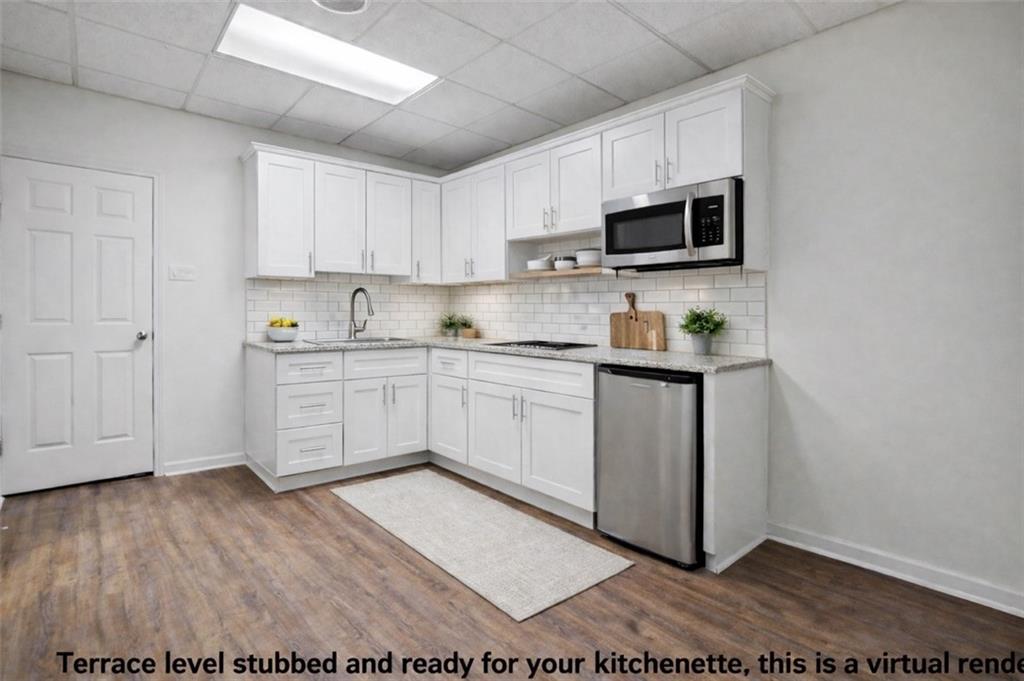 520 Victoria Road Woodstock, GA 30189 - Photo 29 of 42 a kitchen with stainless steel appliances a sink a stove a microwave and cabinets