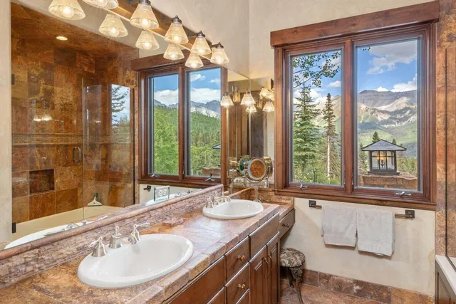 a bathroom with a granite countertop sink and a large mirror