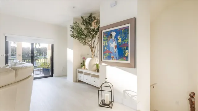 a kitchen with stainless steel appliances granite countertop a stove a refrigerator a sink a microwave and white cabinets with wooden floor