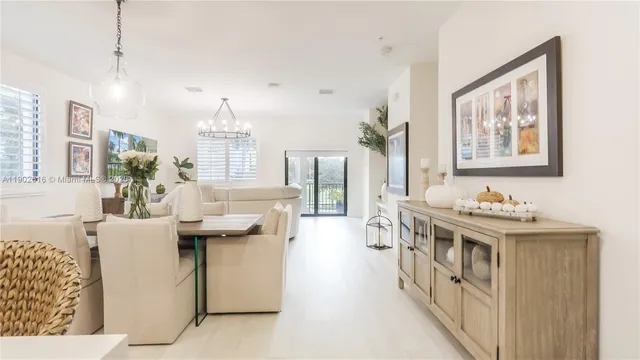 a kitchen with stainless steel appliances kitchen island granite countertop a sink a stove a dining table and chairs