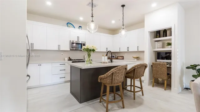 a kitchen with stainless steel appliances granite countertop a sink a stove and a microwave
