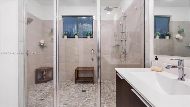 a bathroom with a bathtub sink vanity and mirror