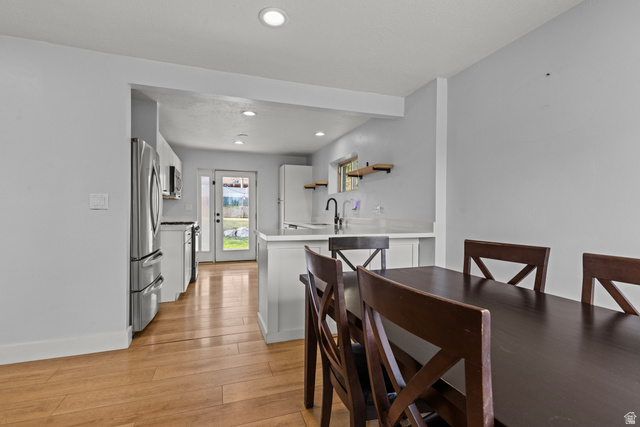 2101 West 3900th Street South Roy, UT 84067 - Photo 19 of 36 Open-concept living space featuring wood-finish flooring, recessed lighting, and a kitchen with stainless steel appliances