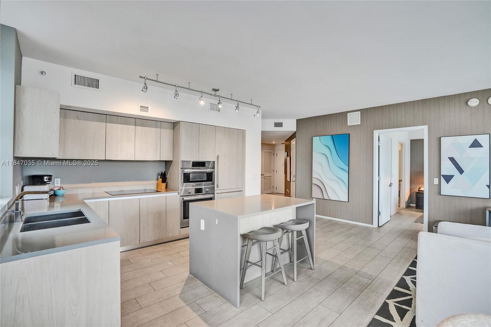 4010 South Ocean Drive, Unit R908 Hollywood, FL 33019 - Photo 12 of 53 a kitchen with stainless steel appliances kitchen island granite countertop a sink and cabinets