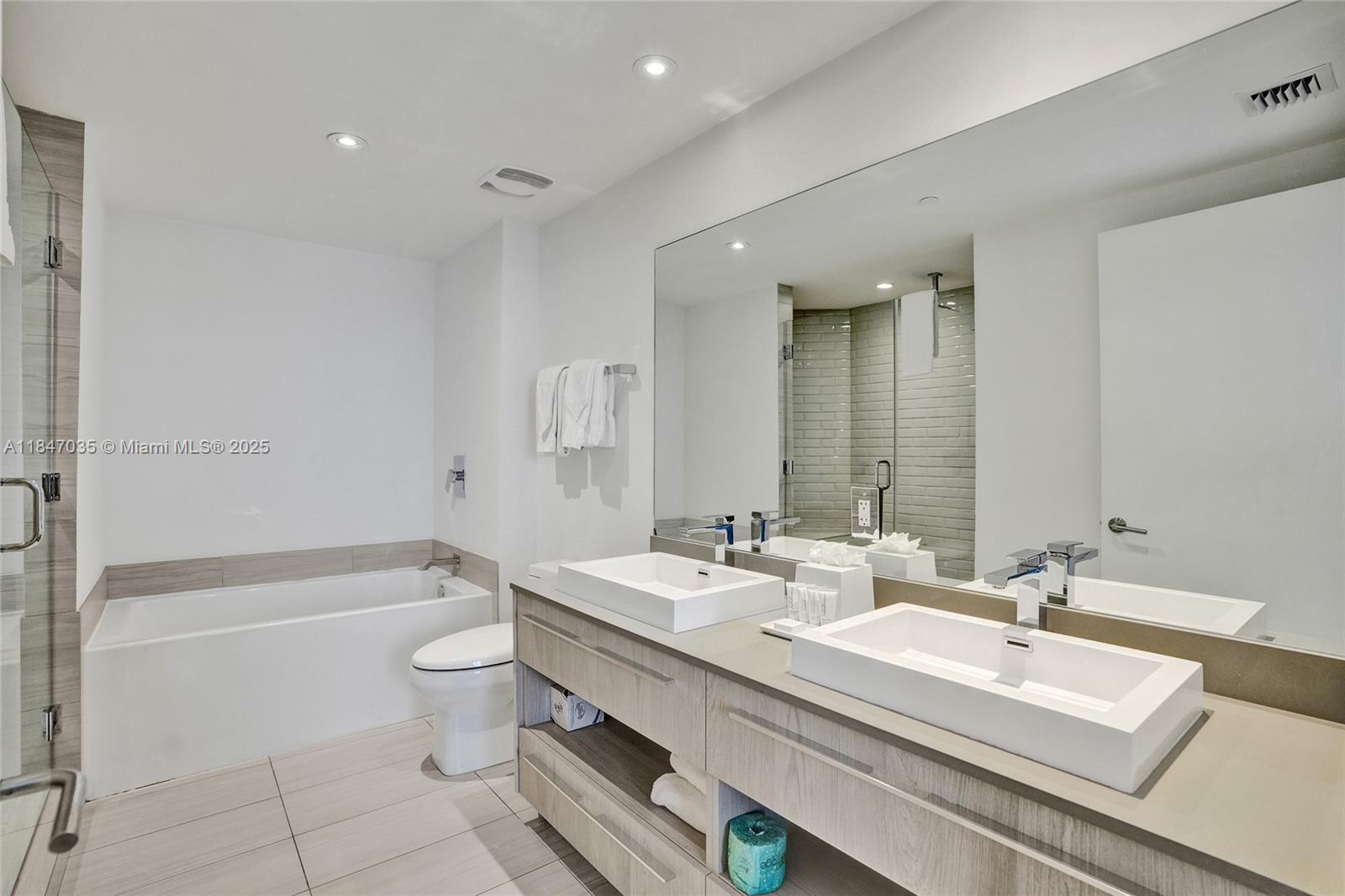 4010 South Ocean Drive, Unit R908 Hollywood, FL 33019 - Photo 17 of 53 a bathroom with a double vanity sink toilet mirror and bathtub