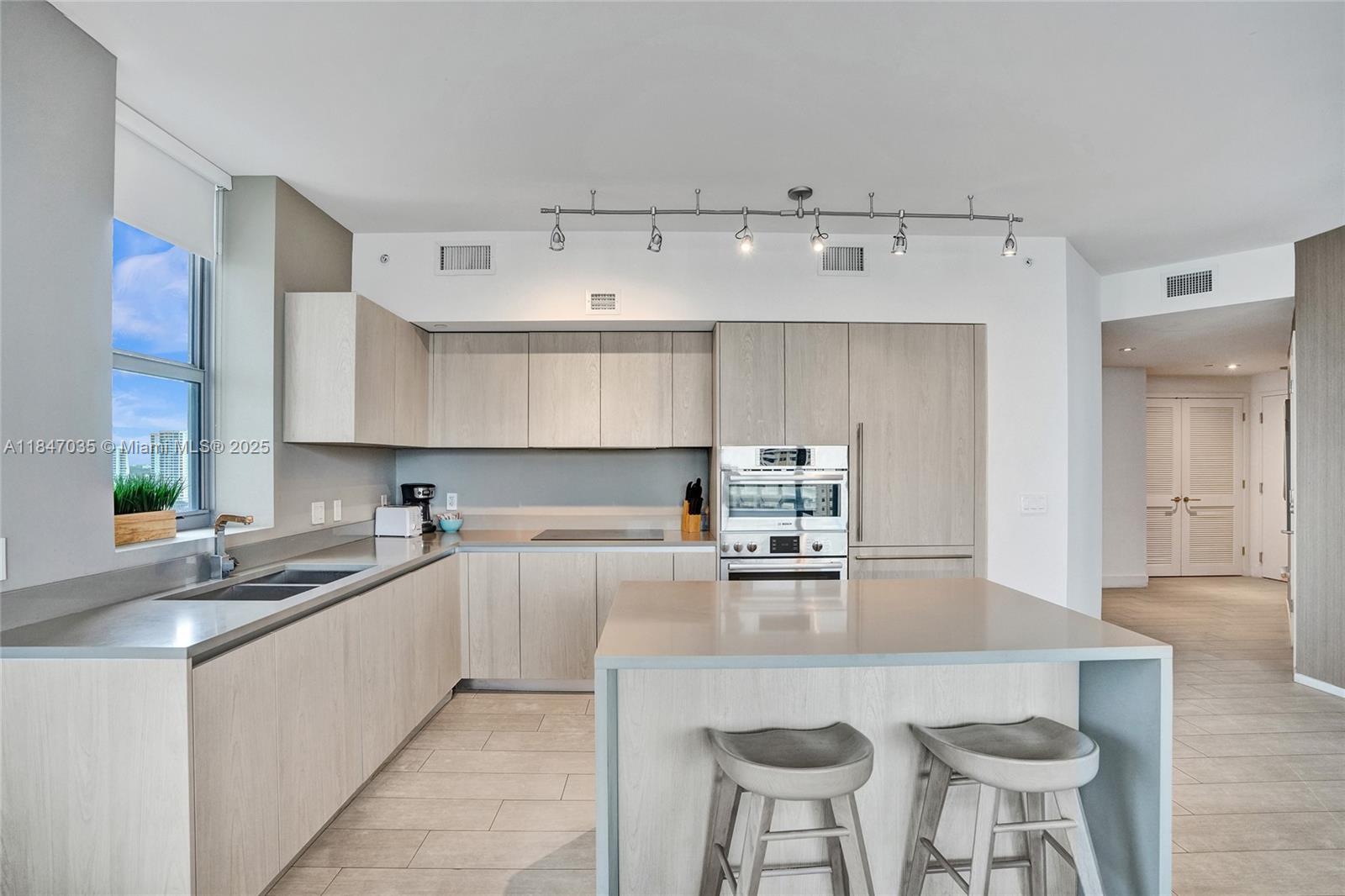 4010 South Ocean Drive, Unit R908 Hollywood, FL 33019 - Photo 10 of 53 a kitchen with stainless steel appliances a sink a stove a table and chairs