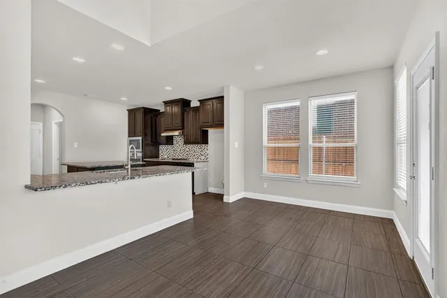a large kitchen with a lot of counter space and wooden floor