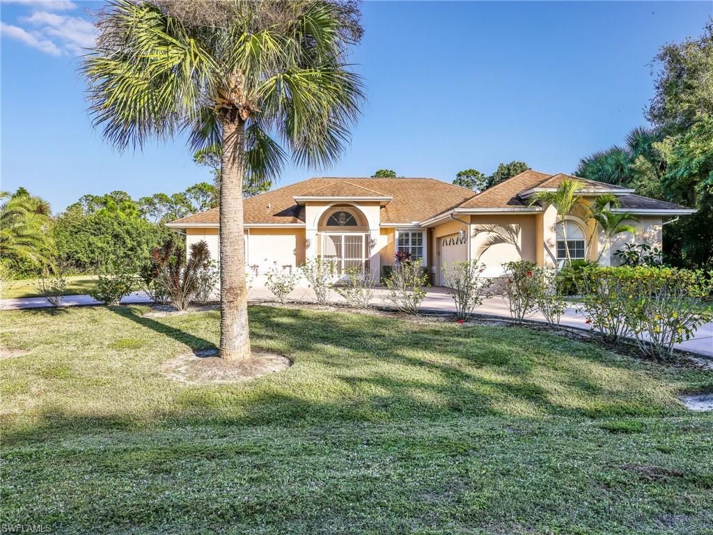 Mediterranean / spanish-style house with stucco siding, a front yard, and a garage