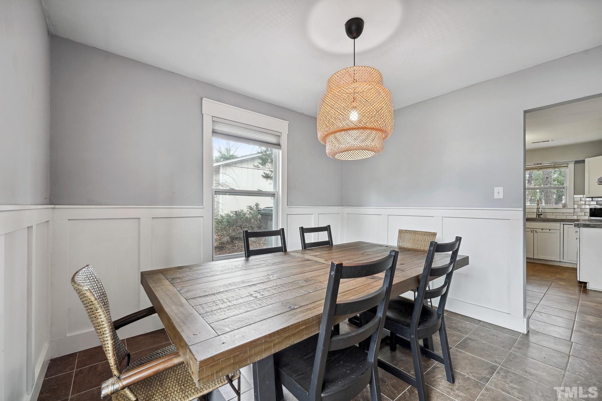 5218 Duraleigh Road Raleigh, NC 27612 - Photo 6 of 27 a dining room with furniture a chandelier and wooden floor