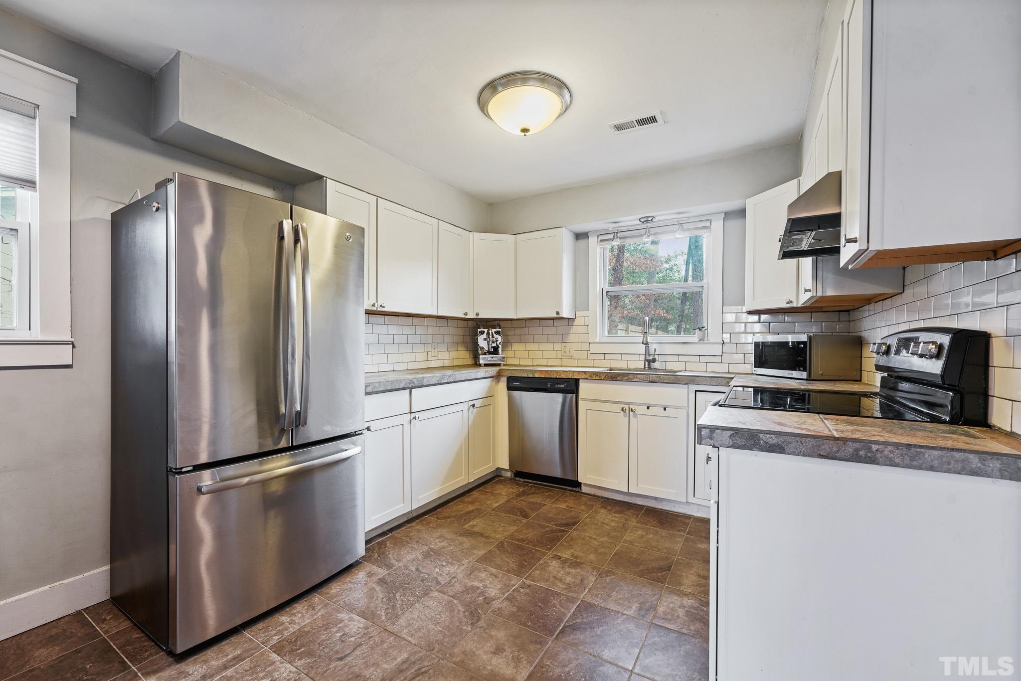 5218 Duraleigh Road Raleigh, NC 27612 - Photo 7 of 27 a kitchen with a refrigerator stove and sink