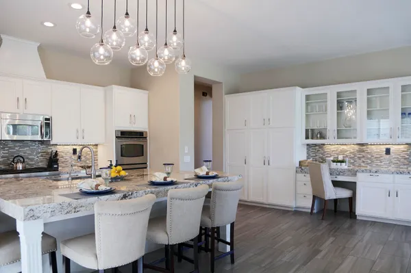 a kitchen with stainless steel appliances a table chairs and a refrigerator