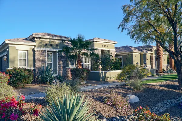 a front view of a house with a yard and fountain