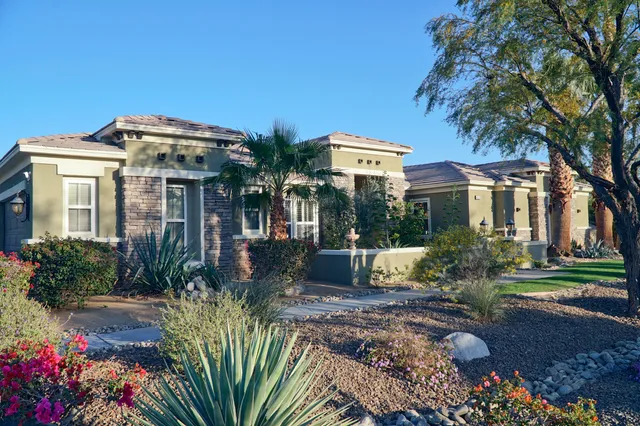 a front view of a house with a yard and fountain