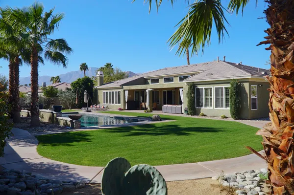 a view of a house with a yard and furniture